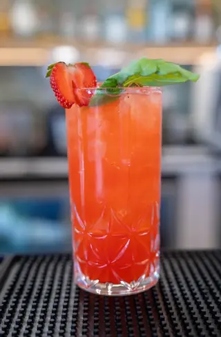 Tall strawberry basil cocktail on the bar
